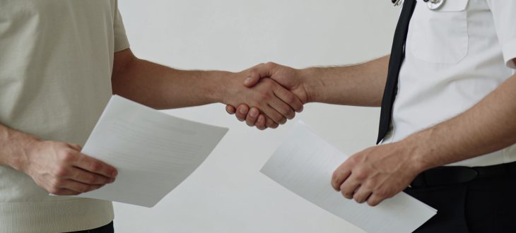 Un citoyen serrant une main avec un fonctionnaire, documents en main.