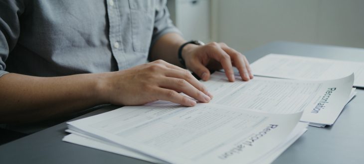 Employé assis à un bureau avec documents de réclamation.