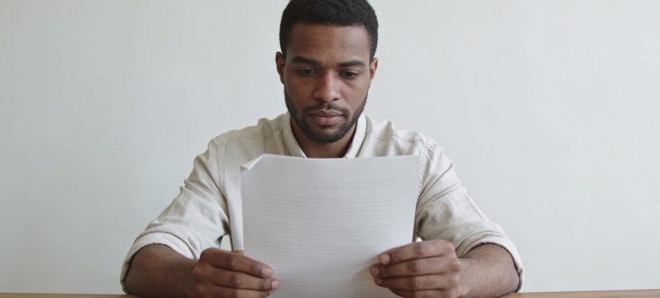 Un homme regardant un document sur un bureau.