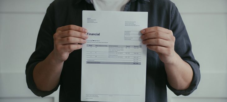 Jeune adulte tenant document financier souriant