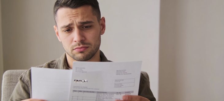 Personne assise tenant des documents financiers, mine preoccupee