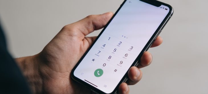 Personne tenant telephone avec numero affiche sur ecran
