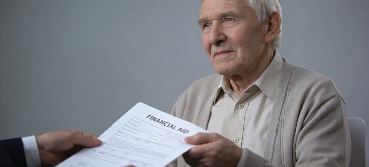 Personne agee assise recevant document d'aide financiere