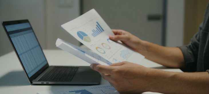 Personne consultant documents financiers sur bureau moderne
