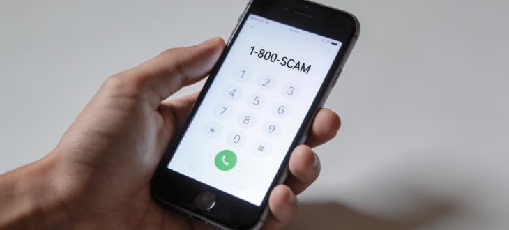 Personne tenant un téléphone affichant un numéro suspect.