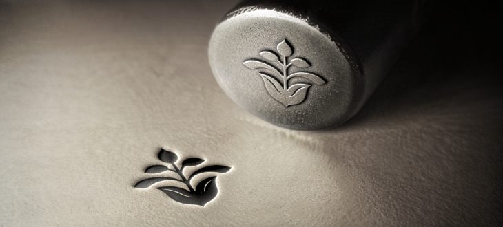 Poincon metallique argent gravé sur surface brillante