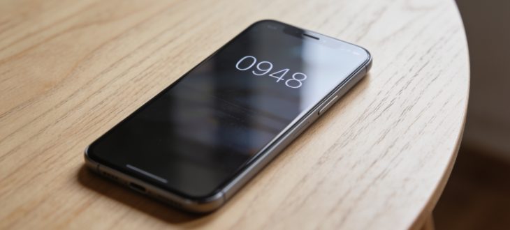 Un téléphone avec un écran affichant le numéro 0948 sur une table en bois.